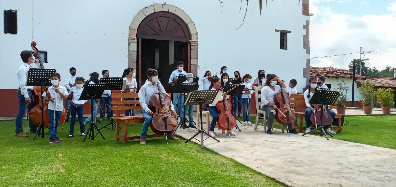 The children from Acatitlán playing their instruments outside.